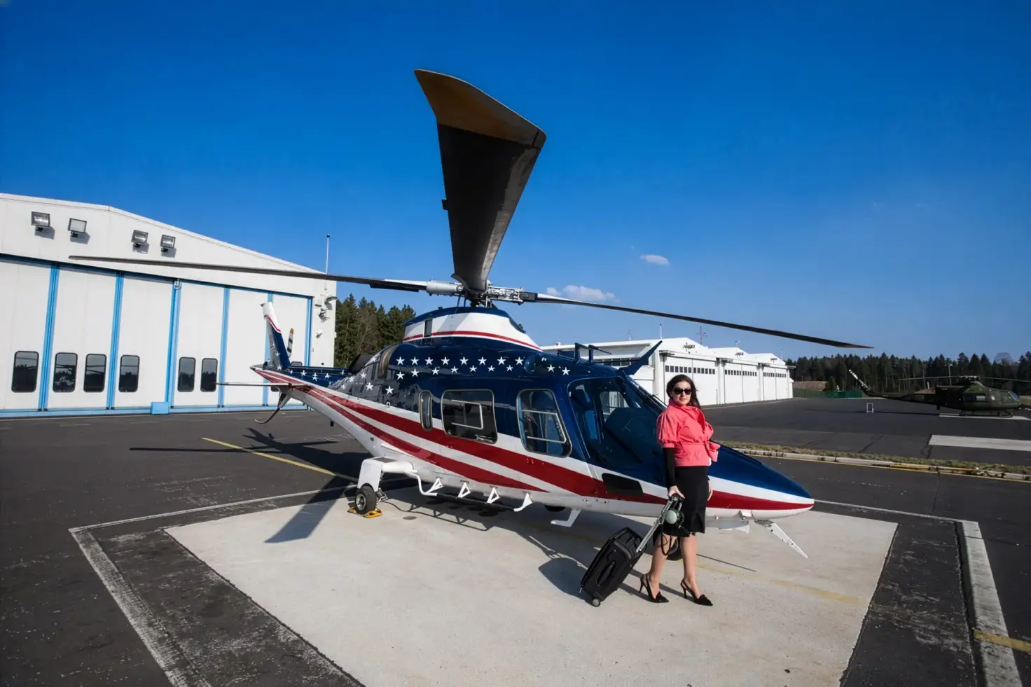 A passenger with rolling luggage stands beside a parked helicopter on an airport apron.